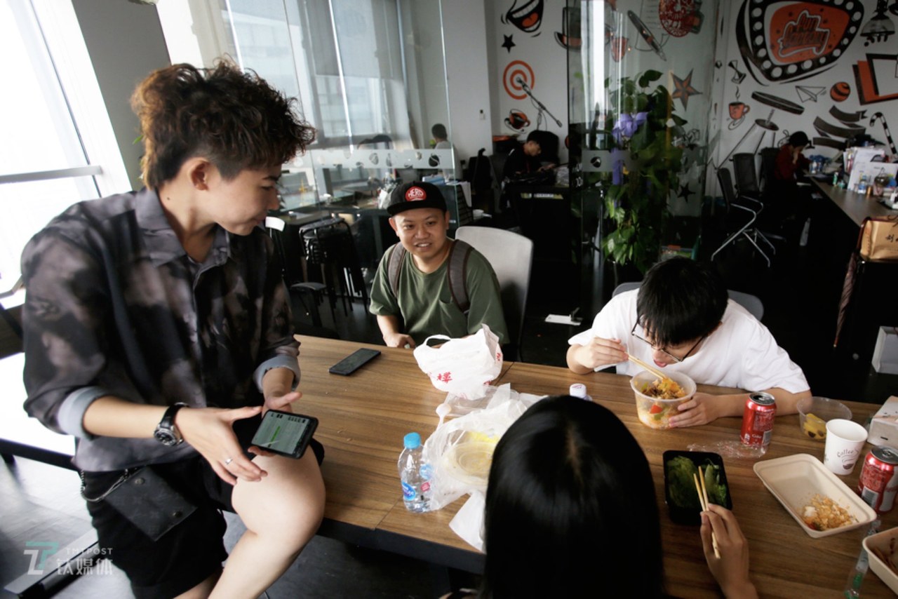 上海，小罗在笑果文化办公室跟同事聊天。